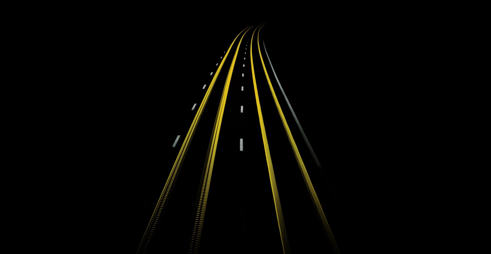 Image en light painting Noir et jaune de feu de véhicules roulant sur une route.