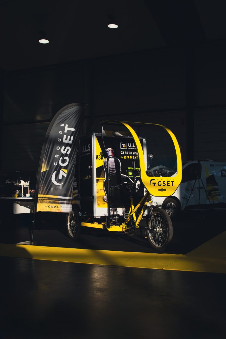 Triporteur électrique du Groupe GSET exposé dans un espace événementiel, solution innovante de livraison urbaine écologique à Rouen. Mobilité douce, logistique urbaine durable, transport du dernier kilomètre.