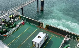 Un camion de livraison E.U.RO. , spécialisé dans le transport urgent, à bord d'un ferry. Le véhicule est prêt à être débarqué sur le quai. Logistique et transport urgent.