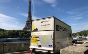 Image d'un camion PRESTA Services garé sur les quais de Seine, avec la Tour Eiffel en arrière-plan.